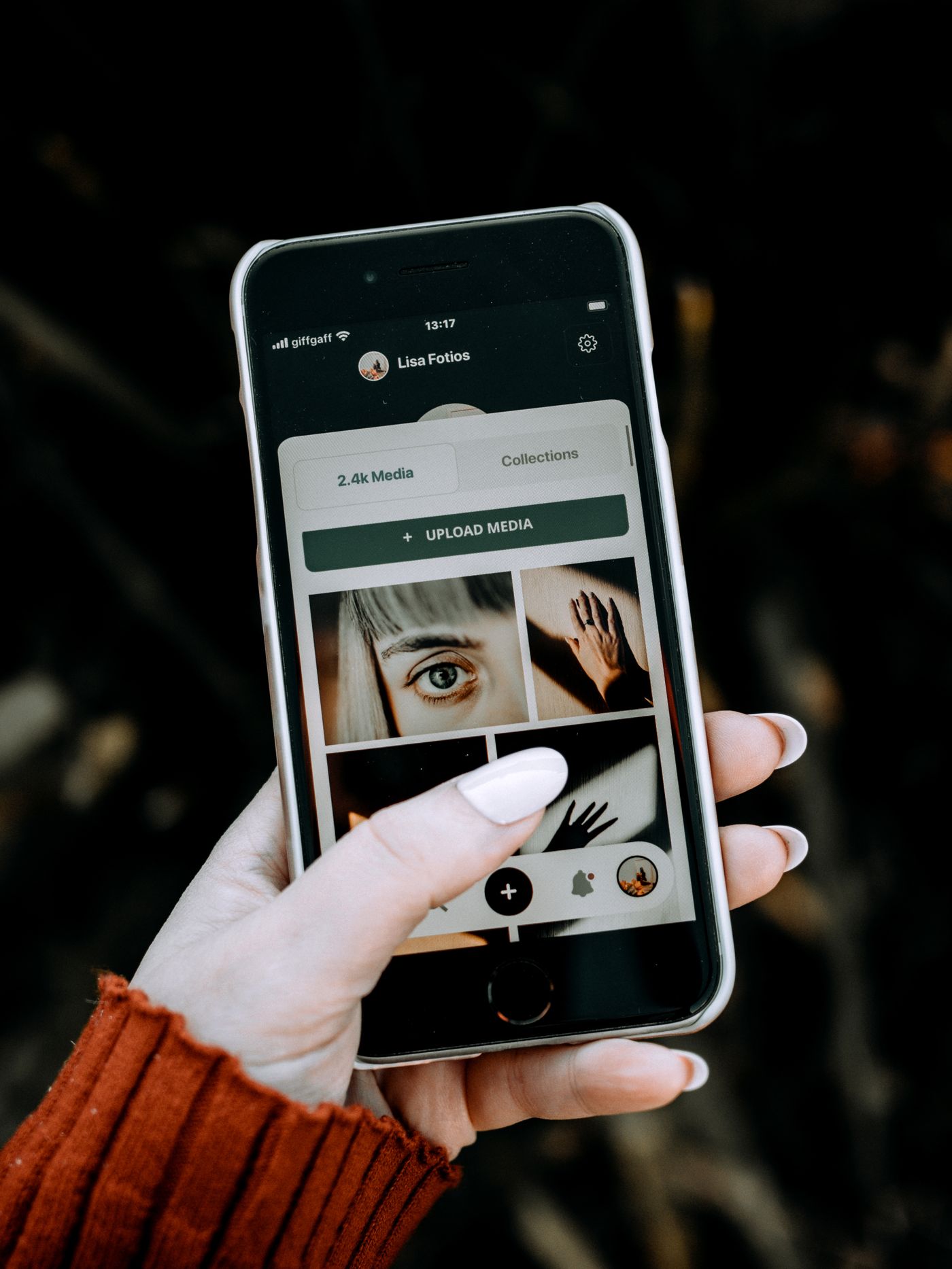 A hand holding a phone, using a polished app in natural light